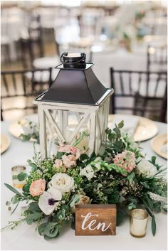 a table topped with a lantern and flowers