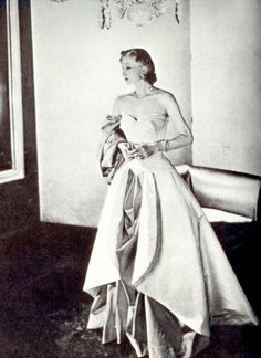 an old black and white photo of a woman in a dress