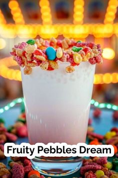 fruity pebbles dream drink in a glass surrounded by candy and candies with the words, fruity pebbles dream written above it