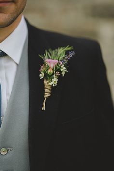 a man wearing a suit and tie with a boutonniere on his lapel