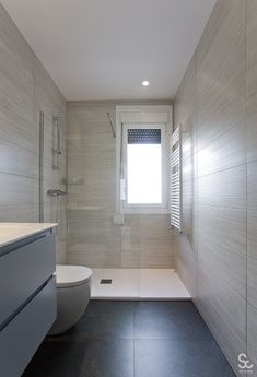 a bathroom with a toilet, sink and shower stall in the middle of it's walls