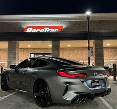 a grey sports car parked in front of a store at night with the name ranetraf on it