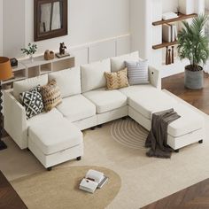 a living room with white couches and pillows