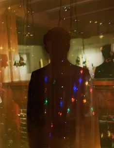 a person standing in front of a window with lights on it's back side