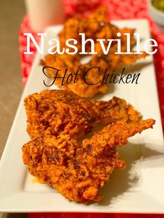 a white plate topped with fried chicken on top of a table