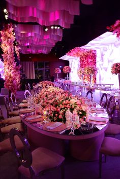 a long table is set up with flowers and place settings for an elegant dinner party