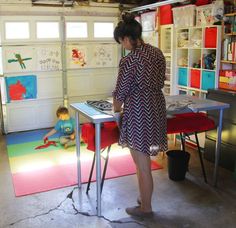 a woman standing at a desk in a garage