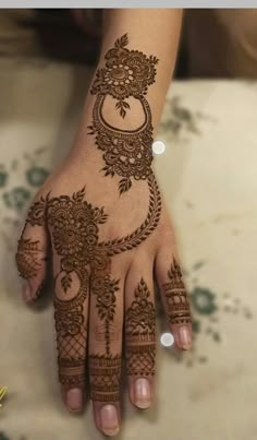 a woman's hand with henna tattoos on it