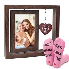 two feet in pink socks next to a wooden frame with a heart hanging from it