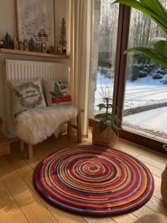 a living room filled with furniture and a large window covered in snow next to a potted plant