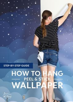 a woman standing on top of a wall with her arms in the air and writing how to hang peel & stick wallpaper