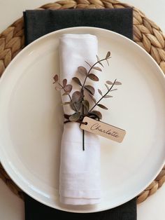 a white plate topped with a napkin and a flower