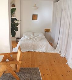 a bed sitting in the middle of a bedroom next to a wooden chair and rug