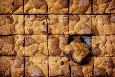 chocolate chip cookie bars arranged in squares on a baking sheet with a bite taken out