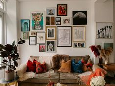 a living room filled with furniture and lots of pictures on the wall above it's couch