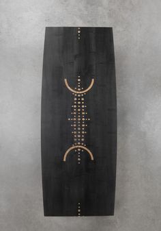 a black and gold surfboard hanging on the wall