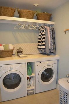 a washer and dryer in a laundry room with baskets on the shelves above them