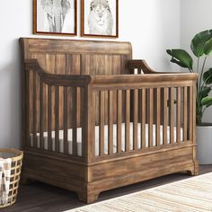 a baby crib with two pictures on the wall