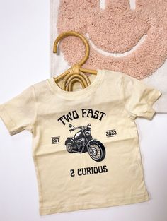 Celebrate your little one's second birthday in style with this adorable cream-colored shirt featuring a fun and charming motorcycle theme. The statement "Two Fast, Too Curious" adds a playful touch to the design, perfectly capturing the adventurous spirit of your young boy. Whether he's zooming around the house or exploring the world with endless curiosity, this shirt is sure to bring a smile to everyone's face. Made with high-quality materials, it's not only cute but also comfortable for your a Two Much Fun Birthday Boy, Two Fast Too Curious, Two Fast Too Curious Birthday, 2 Birthday Boy Themes, 2nd Birthday Themes Boy, Checkered Birthday Theme, Two Fast Two Curious Birthday Party Boy, Two Year Old Birthday Party Boy Themes, 2nd Birthday Boy Themes Unique