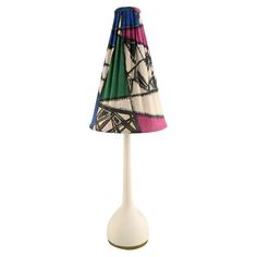 a lamp that is sitting on top of a white base with a multicolored lampshade