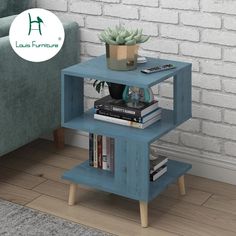 a blue shelf with books and plants on it in front of a brick wall next to a couch