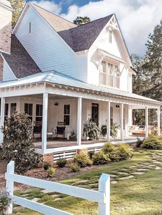 a large white house sitting on top of a lush green field