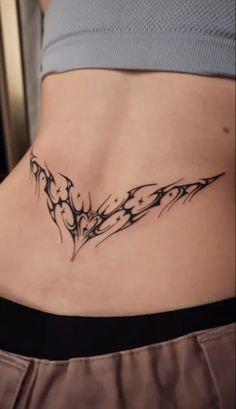 a woman's stomach with a tattoo design on the side and an arrow in the center