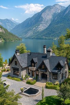 this is an aerial view of a house with mountains in the background and water below