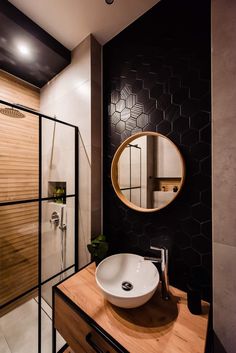 a bathroom with a sink, mirror and stand up shower stall in it's corner