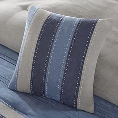 a blue and gray striped pillow on a bed