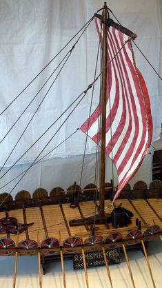 a model ship with an american flag on it's mast and wooden planks