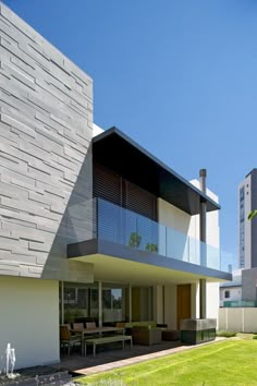 a modern house with an open patio and lawn area