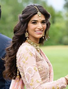 a woman in a pink outfit smiling for the camera with her hand on her hip