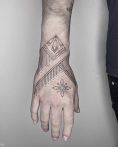 a man's hand with a tattoo on it and a triangle in the middle