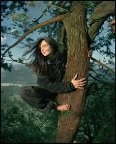 a woman climbing up the side of a tree