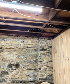 an unfinished room with stone walls and exposed wood beams, before and after the remodel