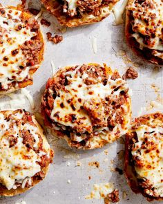 several mini pizzas covered in cheese and meat