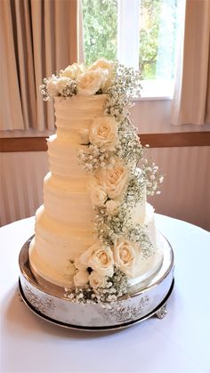 a wedding cake with white flowers and greenery