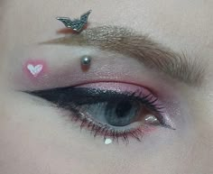 a close up of a person's eye with pink and silver makeup