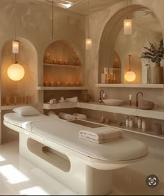 a large white bath room with two sinks and several candles on the shelves above it