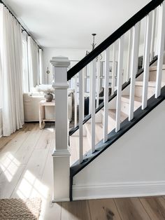 a white staircase with black handrails in a home