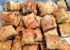 sausage rolls with sesame seeds are piled on top of each other and ready to be eaten