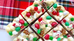 a white chocolate barkle with candy and candies on it sitting on a plaid table cloth