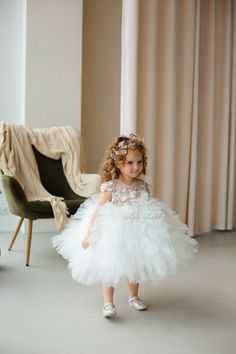 Looking for the perfect dress for your little one's special occasion? Look no further than this beautiful white flower girl dress! Crafted with exquisite attention to detail, this dress is sure to make your little girl feel like a princess on her big day. The delicate tulle tutu and intricate floral detailing are perfect for a first birthday, baptism, first communion, or pageant event. The dress is made from high-quality materials that are gentle on your baby's delicate skin. The soft tulle skir White Tulle First Communion Dress With Ruffles, White Princess Tutu Dress For First Communion, White Princess Baptism Dress With Tulle Skirt, White Tulle Tutu Dress For Wedding, White Tulle Pageant Dress For First Communion, Elegant White Baptism Dress For First Birthday, White Elegant Baptism Dress For First Birthday, White Tulle Baptism Dress For Pageant, White Baptism Dress With Tulle Skirt For Pageant