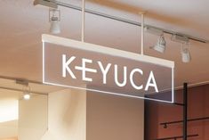 a sign that reads keyua hanging from the ceiling in front of some lamps and lights