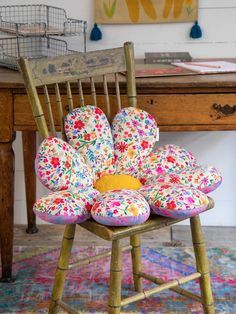 a chair with flowers on it sitting in front of a desk