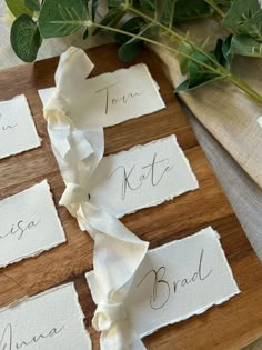 the place cards are laid out on a wooden board