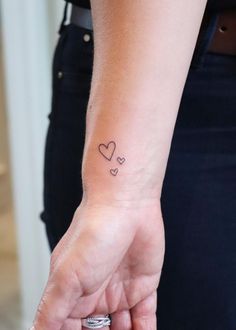 a small heart tattoo on the wrist