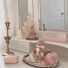 there is a vanity with pink and gold accessories on it