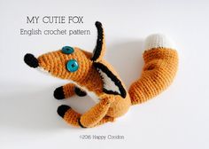 a crocheted stuffed animal that looks like a dog with blue eyes and tail